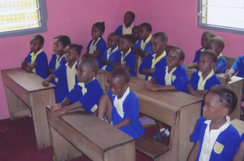Lovia pupils seated at desks in an earlier classroom photograph.