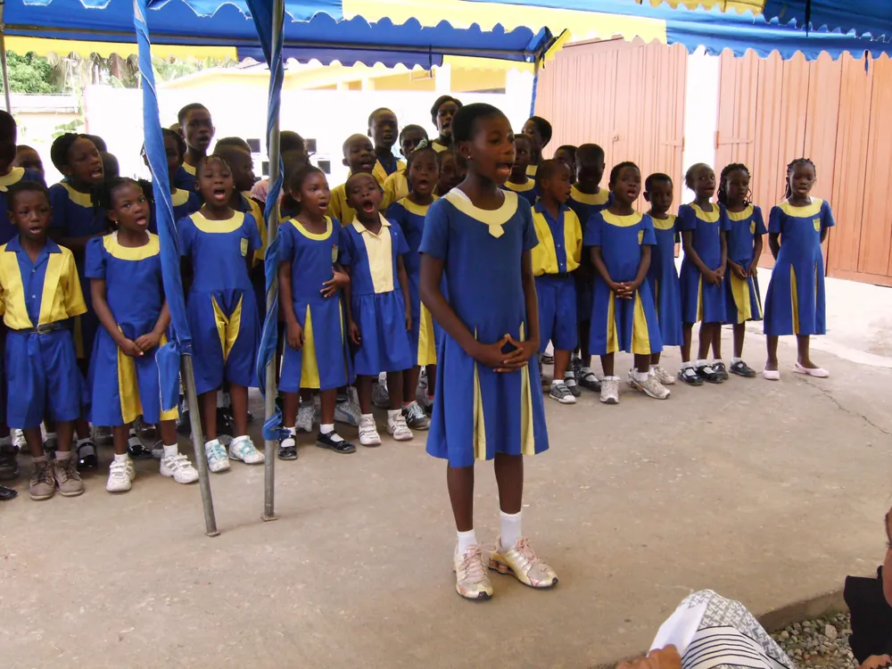 Lovia pupils standing together under a canopy during a school gathering.